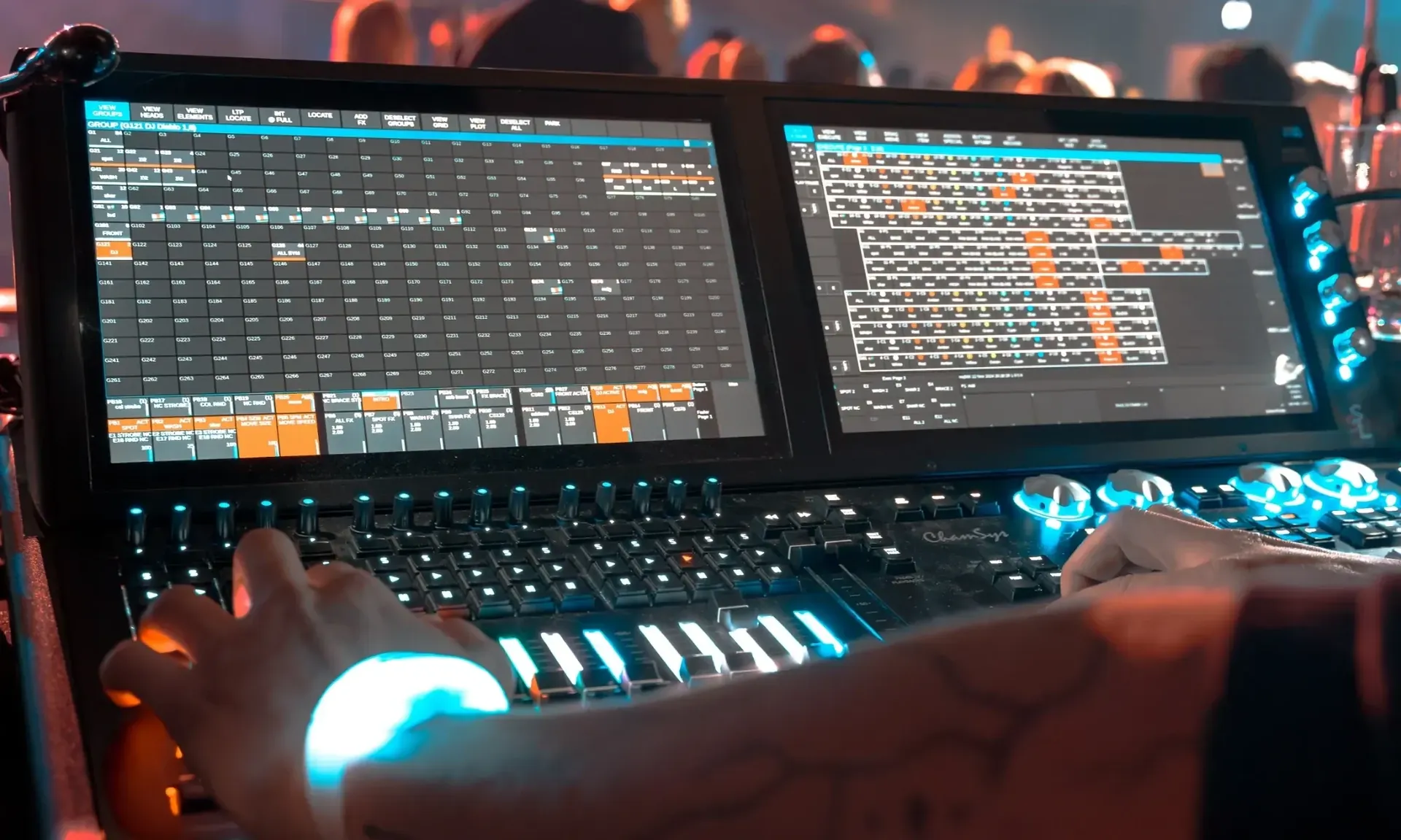 A lighting engineer’s hands on a DMX lighting console, a wristband glowing on one wrist