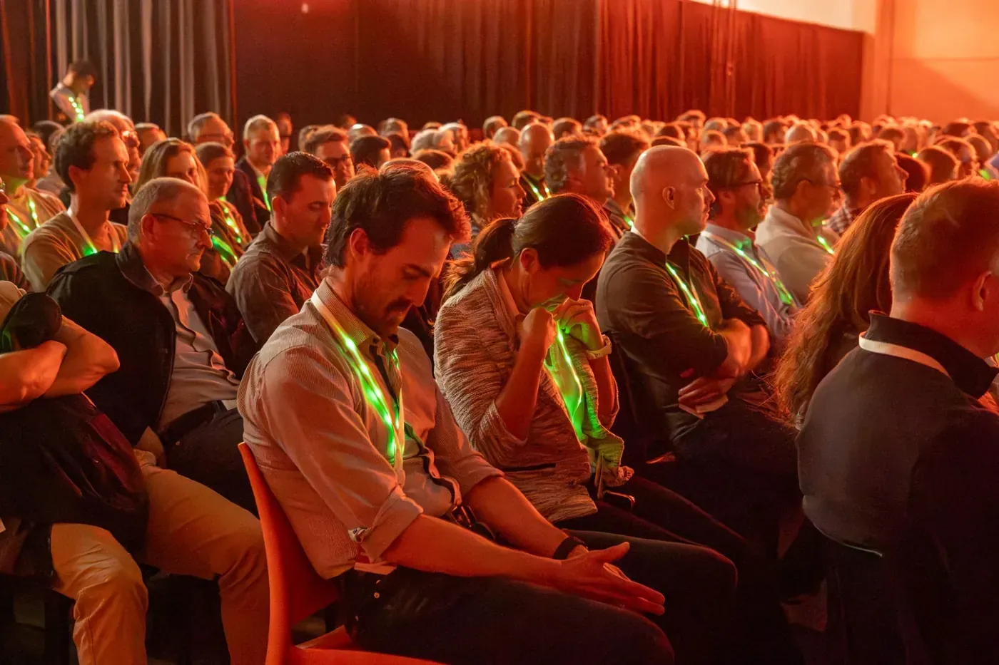 Congress attendees in their seats, each wearing a lanyard lit green