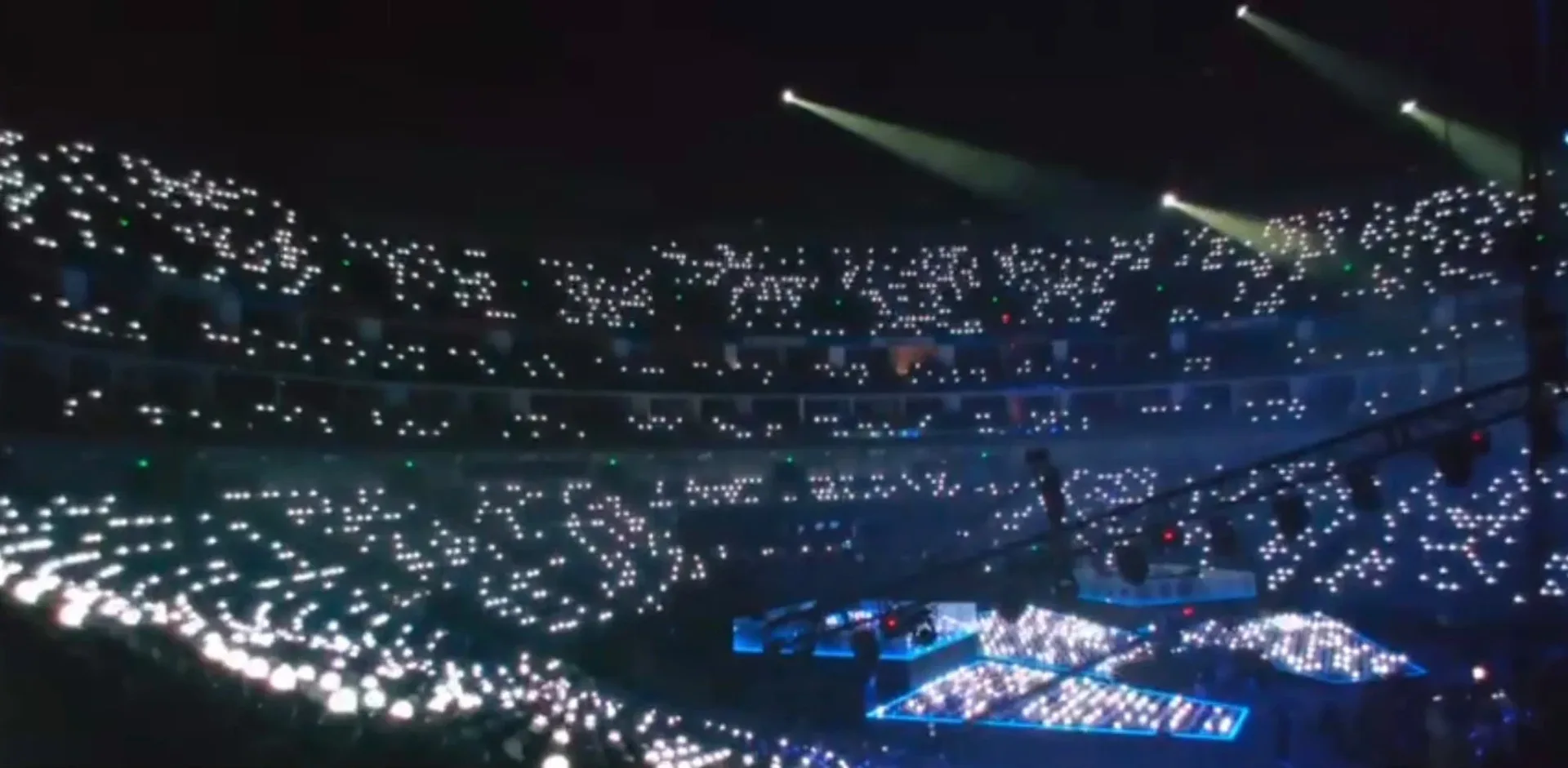 A stadium at an opening ceremony with 17,000 LED wristbands lit white in the stands