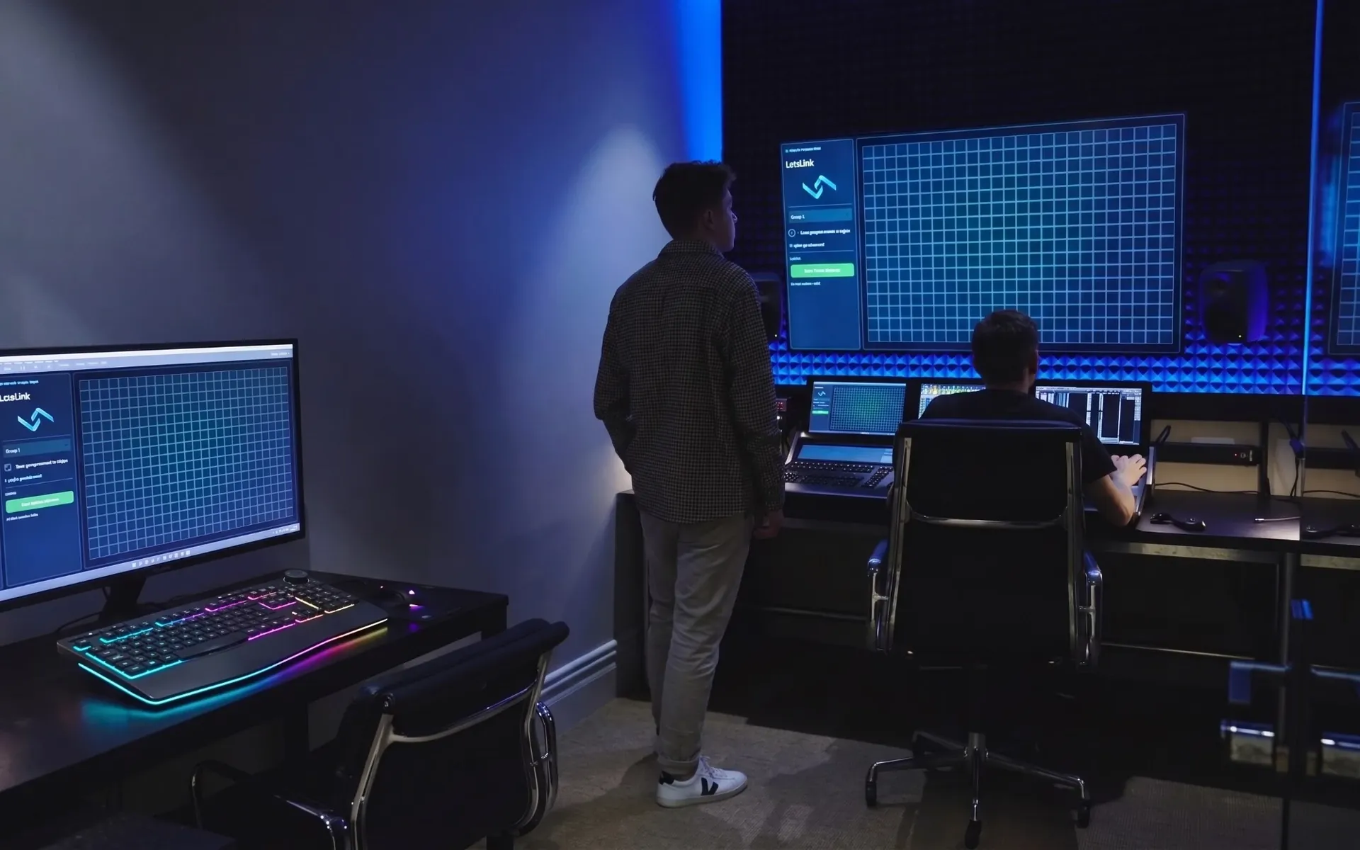 Two LetsLink engineers at a bank of screens programming a show in the pre-visualiser