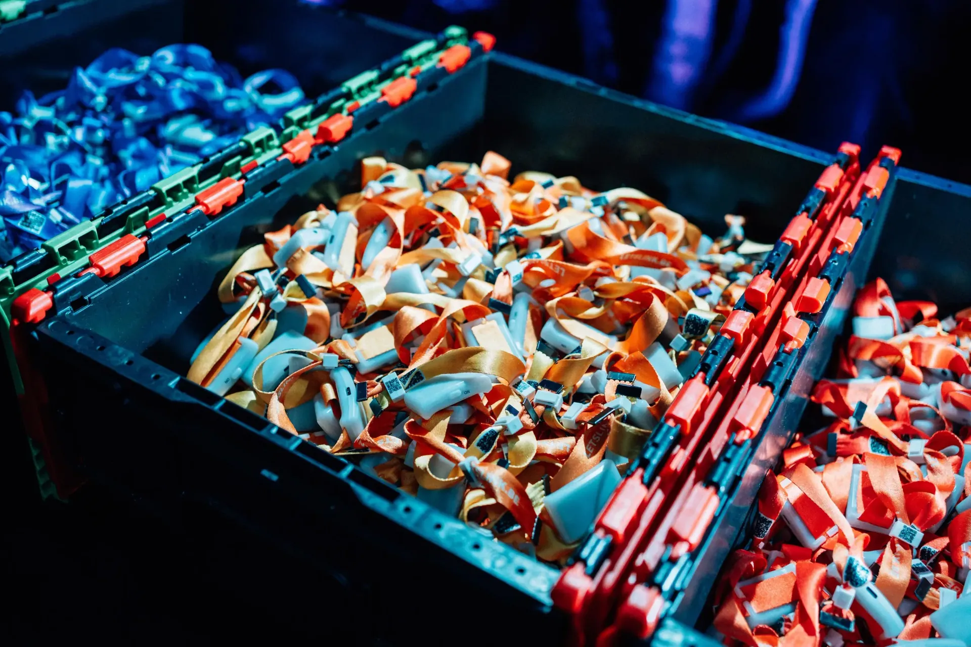 Crates of returned wristbands sorted by colour in the LetsLink warehouse